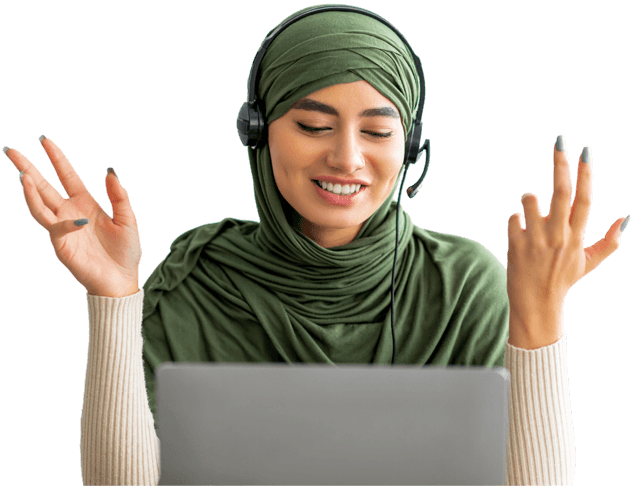 Positive-young-Arab-woman-in-hijab-wearing-headphones-having-online-meeting-on-laptop-at-home